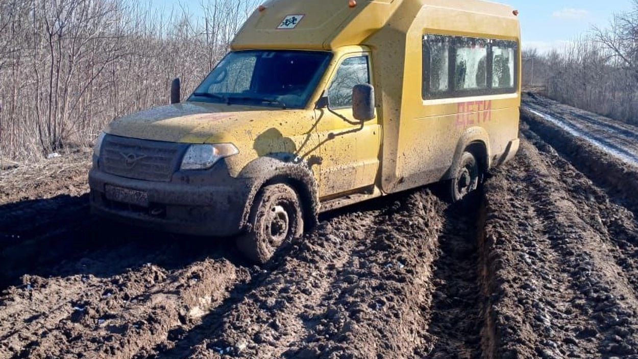 Школьный автобус с большим трудом преодолевает грунтовую дорогу в Покровском