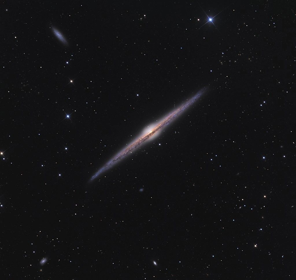 NGC 4565 — это видимая с ребра спиральная галактика, расположенная на расстоянии от 30 до 50 миллионов световых лет от нас в созвездии Волосы Вероники.